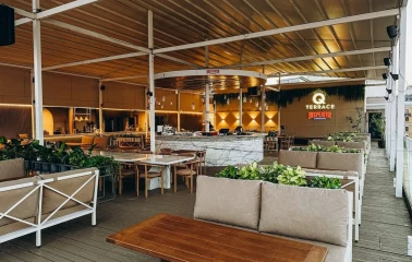 Cozy terrace of the Q Terrace restaurant in Kyiv with soft sofas and a bar area