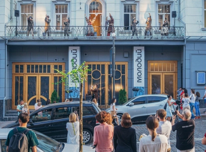 Molodyi Teatr in Kyiv - unique outdoor performance with actors in costumes acting on the theater's balcony while a crowd watches from the street below
