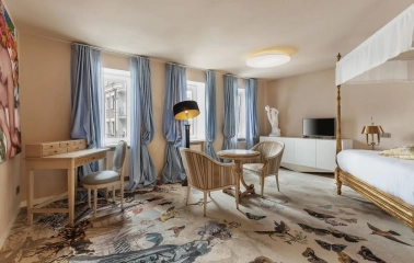 Vozdvyzhenskyi in Kyiv - room featuring canopy bed, blue curtains and patterned carpet