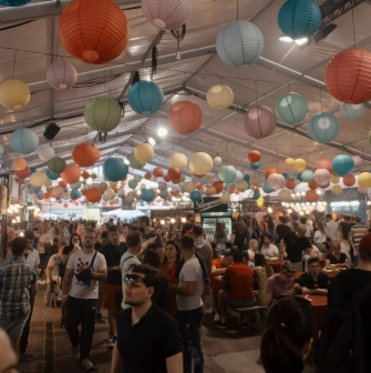 Art-zavod Platforma in Kyiv - spacious food court hall filled with people under a ceiling covered in hundreds of colorful paper lanterns