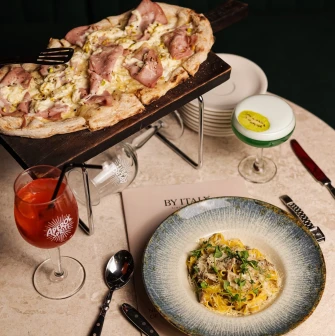 By Italy – truffle pasta and mortadella pizza served with Aperol Spritz and signature cocktail