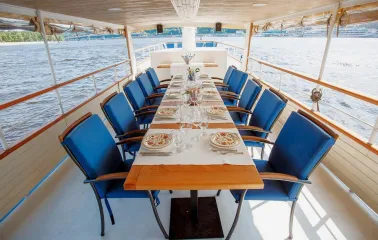 Restaurant Khutorets na Dnipri - table set for a meal on a river boat deck with blue chairs