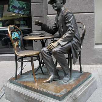 Pasazh in Kyiv - bronze statue of architect Horodetskyi drinking coffee at a table
