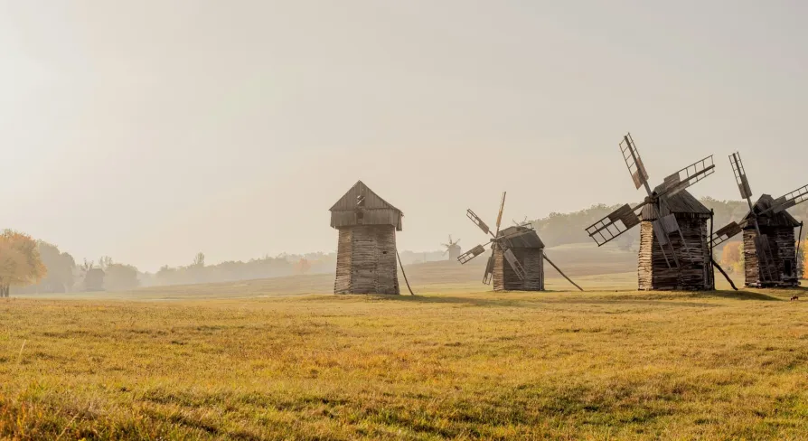Pyrohiv Museum in Kyiv - line of traditional wooden windmills on open grassland