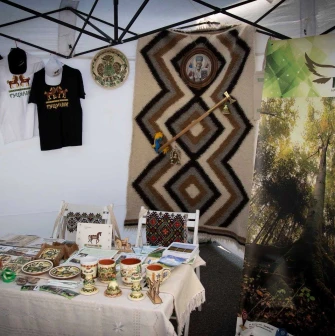 Interior of a pavilion featuring a crafts exhibition, ceramics, a carpet, and Hutsulshchyna t-shirts