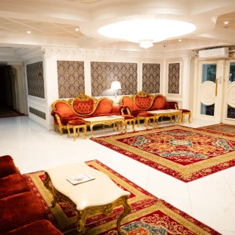 A grand, classic-style reception hall with red furniture at the Royal Olympic Hotel in Kyiv