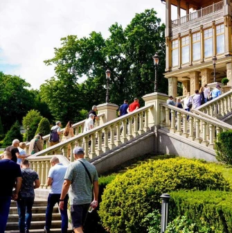 People walking up the grand stairs to the wooden house at the Mezhyhirya Residence