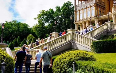 People walking up the grand stairs to the wooden house at the Mezhyhirya Residence