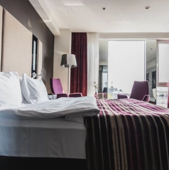 Spacious room at 11 Mirrors Design Hotel in Kyiv with a panoramic window, modern interior and city views