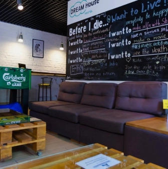 Dream Hostel - lobby area with cozy seating, plants and table football
