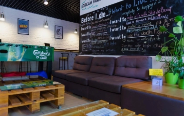 Dream Hostel - lobby area with cozy seating, plants and table football