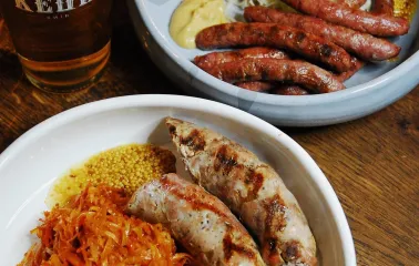 Pab Kedy - close-up of two plates with sausages cabbage and grilled corn