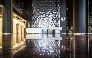 IQ Business Center in Kyiv - lobby featuring shiny metallic reception desk and wavy wall