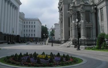 Budynok Horodetskoho in Kyiv - majestic grey facade with columns rising above the flowerbed