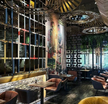 Restaurant Chary - large dining hall with a cultural mural and wire mesh screen dividers