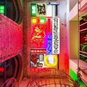 Restaurant Kytaiskyi Pryvit - colorful interior wall display of stacked neon signs and artwork