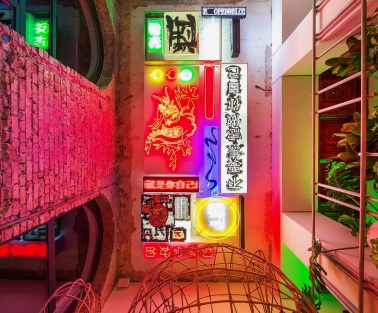 Restaurant Kytaiskyi Pryvit - colorful interior wall display of stacked neon signs and artwork