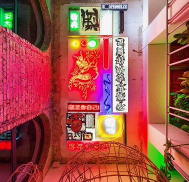 Restaurant Kytaiskyi Pryvit - colorful interior wall display of stacked neon signs and artwork