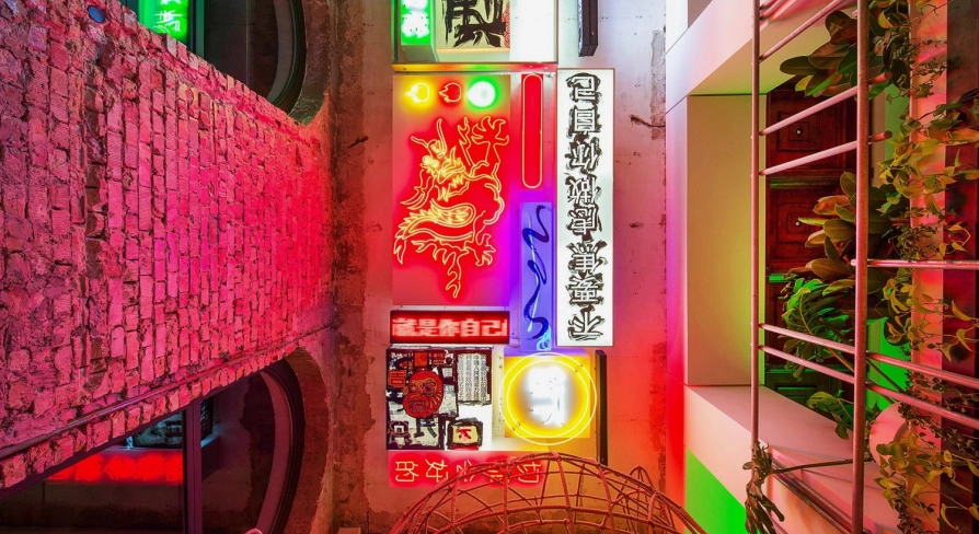 Restaurant Kytaiskyi Pryvit - colorful interior wall display of stacked neon signs and artwork