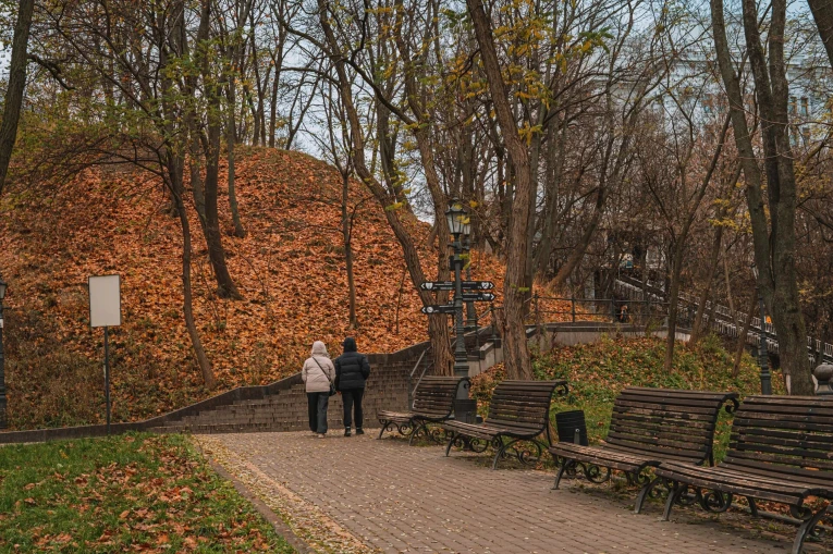 Volodymyrska Hill in Kyiv - park alley with wooden benches and autumn leaves