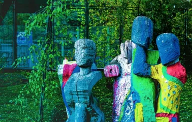 Samosad in Kyiv - artistic rough-hewn wooden sculptures painted in bright colors standing amongst the greenery