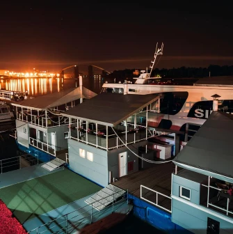 Poshtova Square in Kyiv - night view of the river pier with docked ships and lights reflecting on water