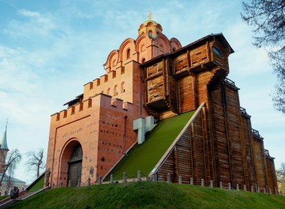 Golden Gate in Kyiv - reconstructed medieval gate with red brick walls, wooden fortifications and grassy slope