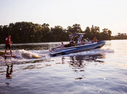 X-Park in Kyiv - motorboat towing a wake surfer on the shimmering river water