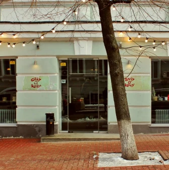Svit Kavy in Kyiv - light blue cafe facade with large glass windows and tree