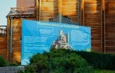 Golden Gate in Kyiv - informational poster near the wooden walls explaining the history and accessibility of the monument