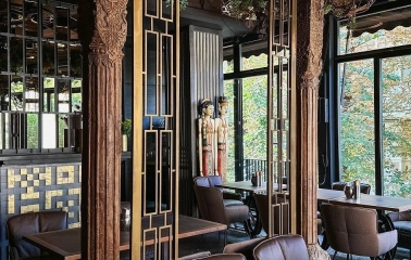 Restaurant Chary - interior with carved wooden columns and brown leather chairs