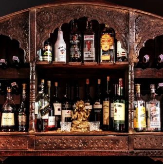 Collection of alcoholic beverages on a carved wooden shelf