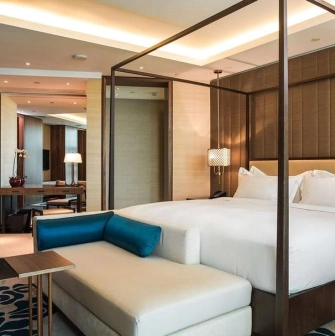 Presidential room at Hilton Kyiv with a large four-poster bed, leather sofa and spacious interior