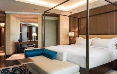 Presidential room at Hilton Kyiv with a large four-poster bed, leather sofa and spacious interior