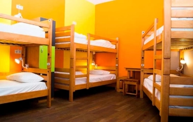 Bright dorm room with orange walls and wooden bunk beds at Dream Hostel in Kyiv