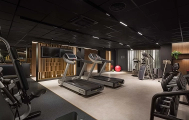 Radisson Blu - well-lit hotel fitness center with cardio equipment and weights