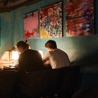 Visitors at a table during an evening at the restaurant with paintings on the walls