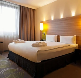 Large double bed with white linens in a Holiday Inn Kyiv room
