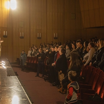 Teatr Voiennykh Dii in Kyiv - theatrical performance with shirtless actors in camouflage pants standing on a stage before the audience