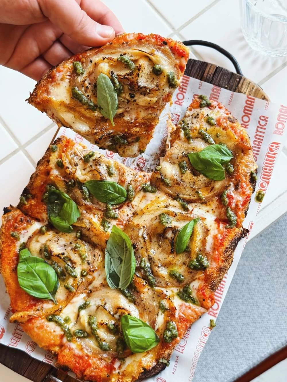 Pizza with pesto sauce and basil at Romantica