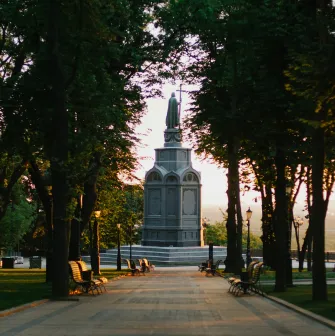 Monument to Vladimir the Great - view of the statue standing at the end of a shady tree-lined park alley