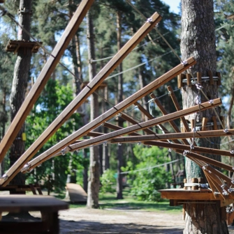 Seiklar Park in Kyiv - complex fan-shaped wooden obstacle attached to a pine tree trunk