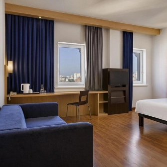 Ibis Kyiv City Center in Kyiv - room interior with blue curtains, sofa and desk