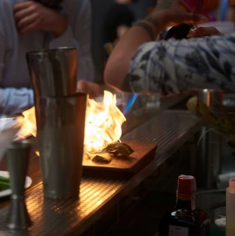 Preparing a meal with an open flame at Pink Freud restaurant