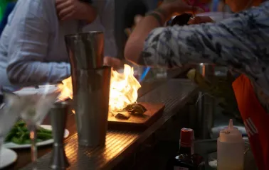 Preparing a meal with an open flame at Pink Freud restaurant