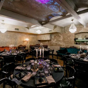 Vintage interior of Alchemist Bar with round tables and candles