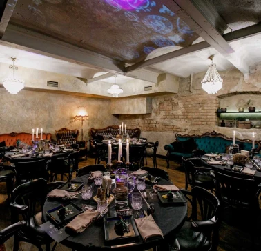 Vintage interior of Alchemist Bar with round tables and candles
