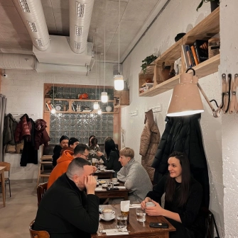 Spelta - dining area with wooden tables industrial lighting and a large counter