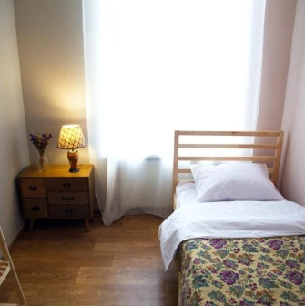 Single room with a wooden bed at Kashtan Guest House in Kyiv