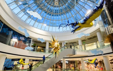 Interior of the Globus shopping center with a transparent dome and bright art installations